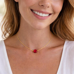 gold necklace with a red pendant
