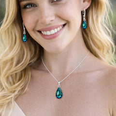 silver necklace with a blue teardrop pendant and matching earrings.