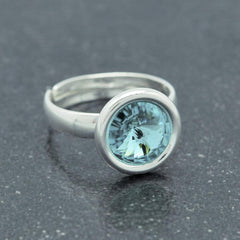 Adjustable sterling silver ring with a faceted light turquoise stone in a polished round setting