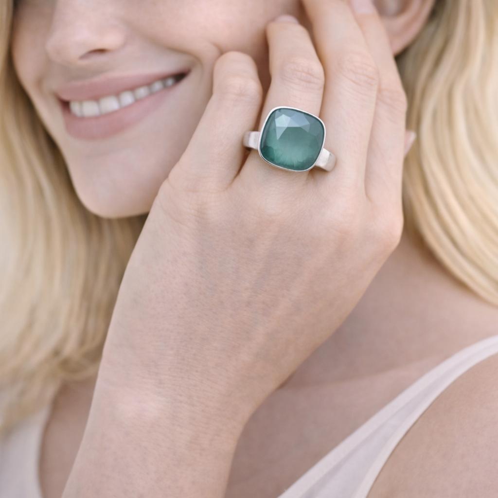 green gemstone ring with a silver band