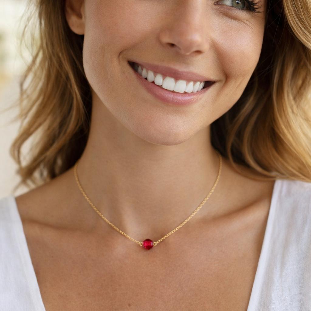 gold necklace with a red gemstone