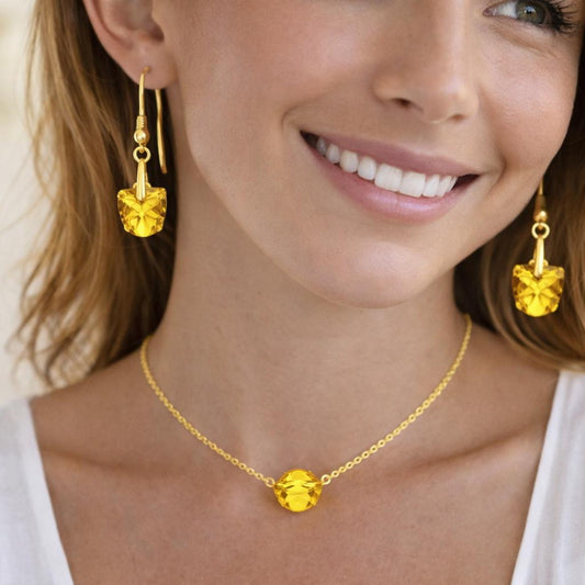  gold necklace and earrings with yellow gemstones.