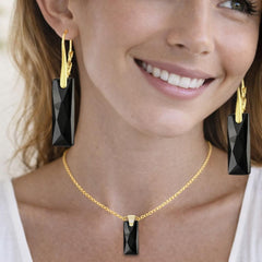 gold necklace and black earrings