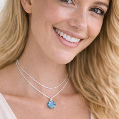 silver necklace with a blue pendant