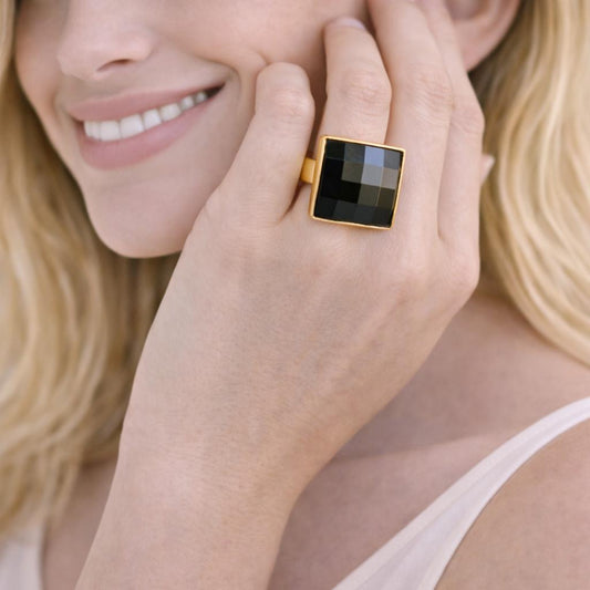 gold ring with a black square stone 