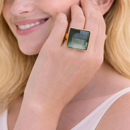 green gemstone ring with gold band.