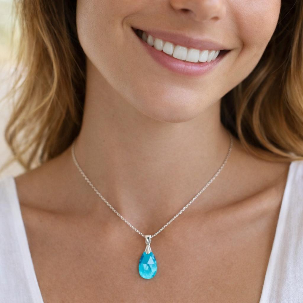 silver necklace with a blue teardrop pendant